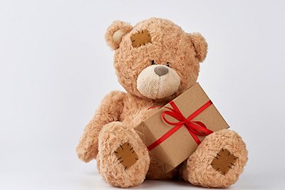 cute-big-beige-teddy-bear-holds-brown-box-with-red-ribbon