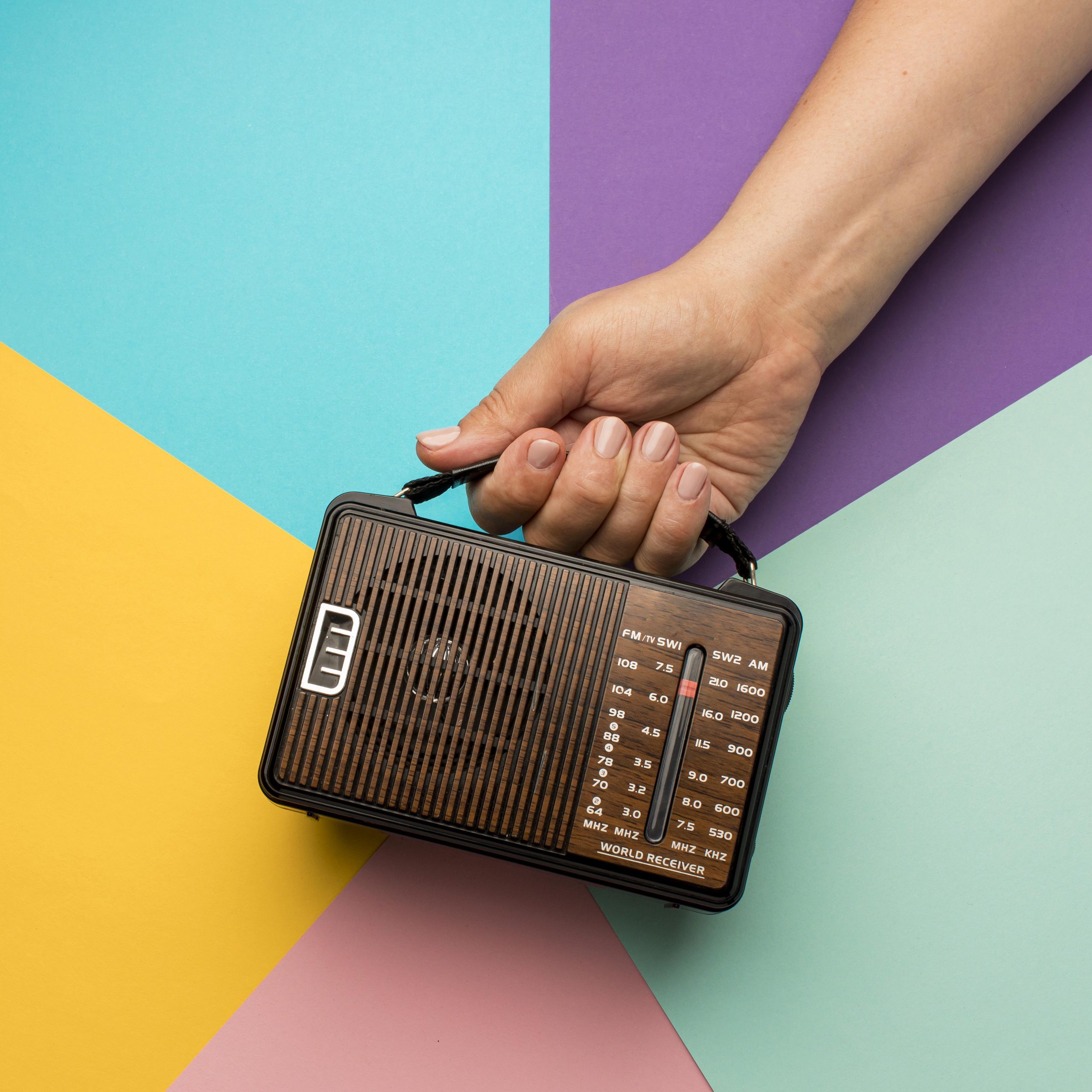 person-holding-retro-broadcast-radio-receiver